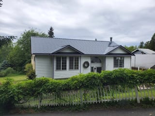 Black Interlock Slate aluminum roof on a white home with a metal roof in a rural setting, Bremerton, Washington