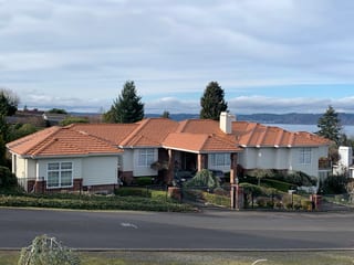 Copper Penny Interlock Shake aluminum roof on a white single-storey home with a metal roof and a chimney, Federal Way, Washington