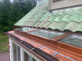 Before: a worn out clay tile roof on the home, Bellingham, Washington, ahead of a Copper Penny Interlock Shake aluminum roof