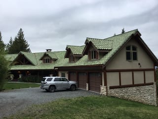 Before: a worn out clay tile roof on a tan home with brown trim and green roof, Bellingham, Washington, ahead of a Copper Penny Interlock Shake aluminum roof
