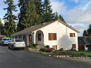 Before: a concrete tile roof with broken tiles on the home, Shoreline, Washington, ahead of a Tile Red Interlock Tile aluminum roof