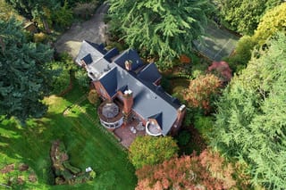 Black Interlock Slate aluminum roof on a red brick home with dormers in a lush green Seattle, Seattle, Washington