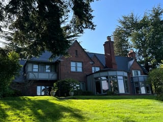Black Interlock Slate aluminum roof on a red brick Tudor home with a black metal roof in a, Seattle, Washington