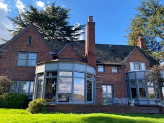 Before: a worn out wood shake roof on the home, Seattle, Washington, ahead of a Black Interlock Slate aluminum roof