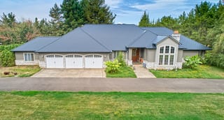 Black Interlock Slate aluminum roof on a gray ranch-style home with a metal roof among tall trees, Ridgefield, Washington