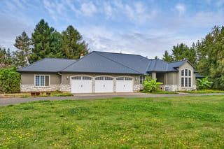 Black Interlock Slate aluminum roof on a tan ranch home with a black metal roof in a rural setting, Ridgefield, Washington