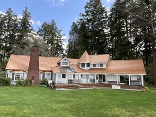Copper Penny Interlock Shake aluminum roof on a cottage-style home among tall evergreen trees, Bremerton, Washington