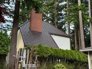 Colonial Brown Interlock Shake aluminum roof on a colonial home with a metal roof in a wooded rural setting, Bellingham, Washington