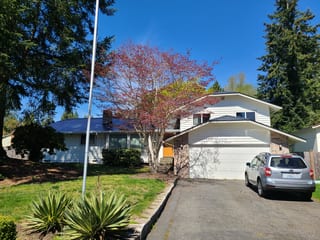 Deep Charcoal Interlock Slate aluminum roof on a white two-storey home with dormers and a large tree, Lynnwood, Washington