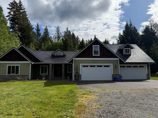 Black Interlock Shake aluminum roof on a two-storey home with black metal roof in a forested rural, Marysville, Washington