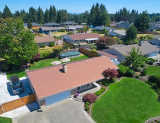 Aged Copper Interlock Shake aluminum roof on a two-storey ranch home with a metal roof in a, Puyallup, Washington
