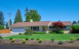 Aged Copper Interlock Shake aluminum roof on a ranch home with a stone facade and a well-manicured lawn, Puyallup, Washington