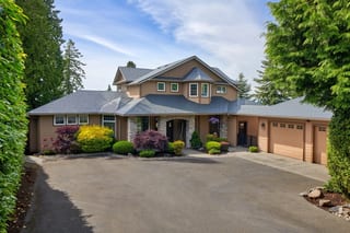 Deep Charcoal Interlock Slate aluminum roof on a beige single-storey home with a metal roof in a forested, Blaine, Washington