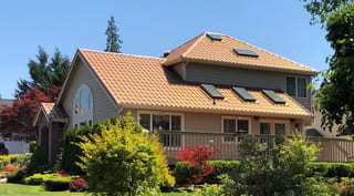 Aged Copper Interlock Tile aluminum roof on a brown single-family home with a gable roof in a lush, Arlington, Washington