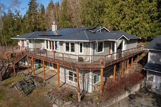 Deep Charcoal Interlock Shake aluminum roof on a grey ranch home with a metal roof on a forested slope, Bellingham, Washington