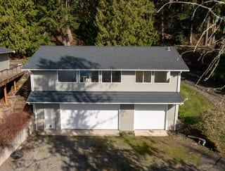 Deep Charcoal Interlock Shake aluminum roof on a modern home with a deep charcoal metal roof among tall, Bellingham, Washington