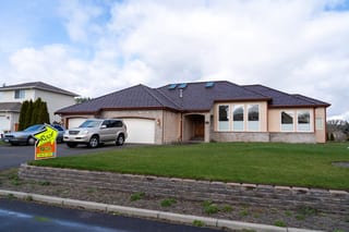 Colonial Brown Interlock Shake aluminum roof on a tan single-storey home with dormers and stone accents, Orting, Washington