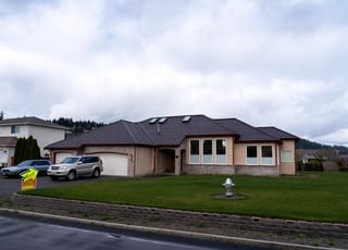 Colonial Brown Interlock Shake aluminum roof on a brown single-storey colonial home with dormers on a, Orting, Washington
