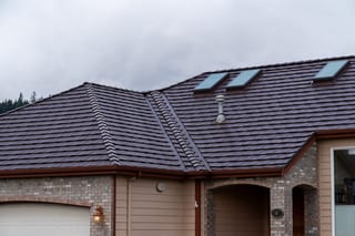 Colonial Brown Interlock Shake aluminum roof on a tan single-storey home with Colonial style among trees, Orting, Washington