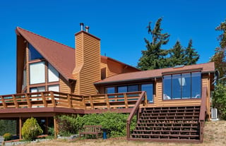 Copper Penny Interlock Cedar Shingle aluminum roof on a brown A-Frame home with a metal roof in a forested rural, Sequim, Washington