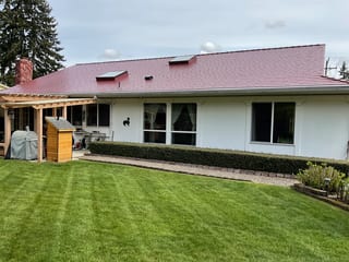 Tile Red Interlock Slate aluminum roof on a white one-storey home with a red metal roof in a, Lakewood, Washington