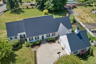 Black Interlock Slate aluminum roof on a white one-storey ranch with a metal roof and a chimney, Enumclaw, Washington