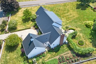 Black Interlock Slate aluminum roof on a white single-storey modern home in a rural suburban, Enumclaw, Washington