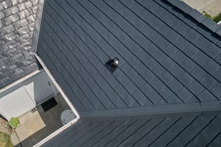 Black Interlock Slate aluminum roof on a grey single-storey home with dormers in a rural setting, Enumclaw, Washington