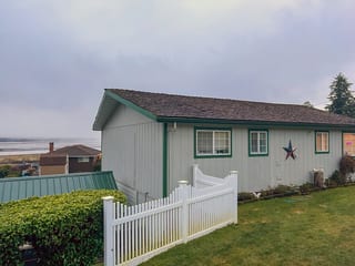 Before: a wind damaged wood shake roof on the home, Hoquiam, Washington, ahead of a Copper Penny Interlock Cedar Shingle aluminum roof