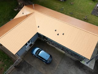 Copper Penny Interlock Slate aluminum roof on a two-storey home with a copper penny metal roof in a, Castle Rock, Washington