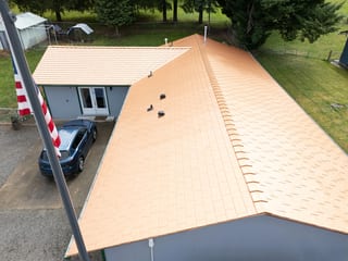 Copper Penny Interlock Slate aluminum roof on a single-storey home with copper roof among trees in rural, Castle Rock, Washington