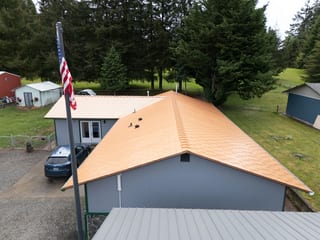 Copper Penny Interlock Slate aluminum roof on a gray one-storey home with a copper penny metal roof in a, Castle Rock, Washington