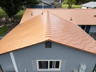 Copper Penny Interlock Slate aluminum roof on a grey one-storey home with a copper metal roof in a rural, Castle Rock, Washington