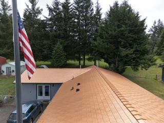 Copper Penny Interlock Slate aluminum roof on a copper roof on a two-storey home in a forested rural, Castle Rock, Washington