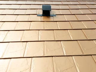 Copper Penny Interlock Slate aluminum roof on a tan two-storey home with dormers in a rural setting, Castle Rock, Washington