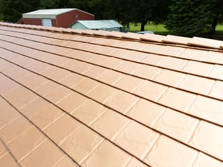 Copper Penny Interlock Slate aluminum roof on a red brick home with copper penny metal roof among tall, Castle Rock, Washington
