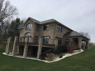 Colonial Brown Interlock Slate aluminum roof on a brown two-storey home with dormers in a wooded rural, Horicon, Wisconsin