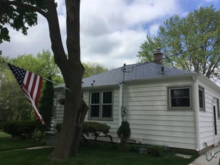 Charcoal Grey Interlock Slate aluminum roof on a white one-storey home with a grey metal roof in a rural, Madison, Wisconsin
