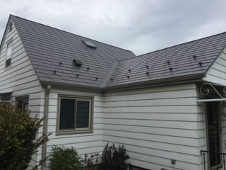 Weathered Interlock Slate aluminum roof on a white single-family home with a metal roof in an urban, Milwaukee, Wisconsin