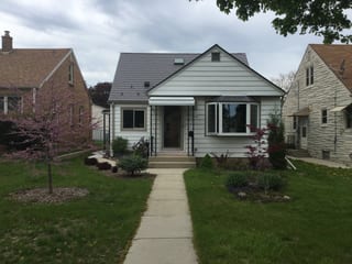 Weathered Interlock Slate aluminum roof on a white single-storey home with dormers among suburban, Milwaukee, Wisconsin