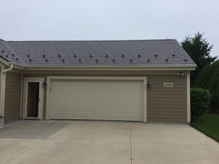 Colonial Brown Interlock Slate aluminum roof on a brown two-storey home with a colonial roof style in a, Port Washington, Wisconsin