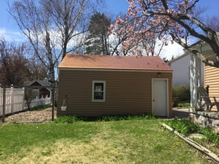 Aged Copper Interlock Slate aluminum roof on a two-storey home with a metal roof among tall trees, Watertown, Wisconsin
