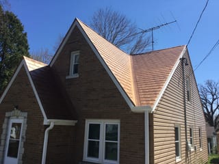 Aged Copper Interlock Slate aluminum roof on a brown house with a metal roof among trees, Watertown, Wisconsin