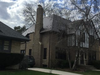 Colonial Brown Interlock Slate aluminum roof on a colonial home with a brown roof and a bare tree in front, Milwaukee, Wisconsin