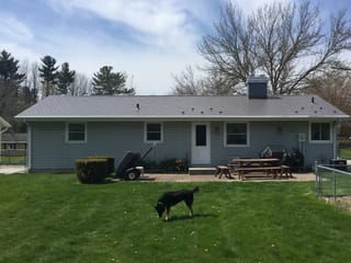Weathered Interlock Slate aluminum roof on a gray ranch home with a metal roof among green grass, Sheboygan, Wisconsin
