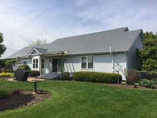 Tudor Brown Interlock Slate aluminum roof on a Tudor Brown ranch home among greenery, Burlington, Wisconsin