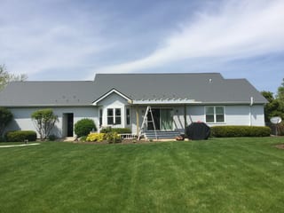 Tudor Brown Interlock Slate aluminum roof on a Tudor Brown metal roof on a single-storey white ranch home, Burlington, Wisconsin