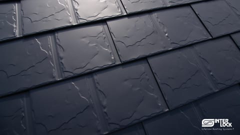 Close-up of Interlock® aluminum shingle panels in the slate profile — Deep Charcoal texture detail