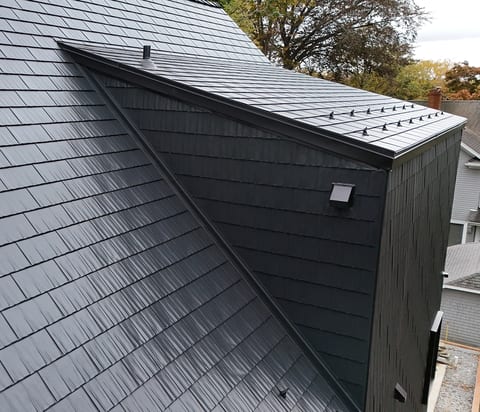 Black aluminum shingle roof and matching wall cladding on a dormer
