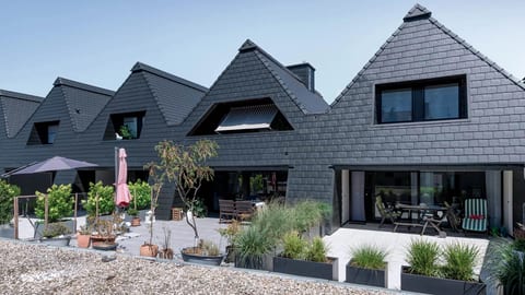 Black aluminum slate siding on a row of modern gabled homes